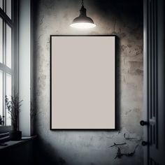 an empty frame hanging on the wall next to a window with a plant in it