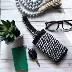 the contents of a purse laid out on a wooden table next to a plant and glasses