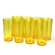 a set of six yellow glass tumblers sitting next to each other