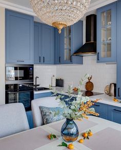 a kitchen with blue cabinets and a chandelier hanging from the ceiling