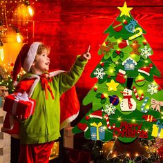 a little boy standing next to a christmas tree