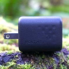 an external charger is placed on a mossy surface