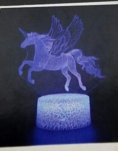 a blue and white horse statue sitting on top of a table next to a black wall