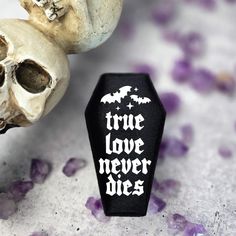 there is a small black box with the words true love never dies next to it