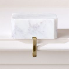 a white marble block with a brass handle