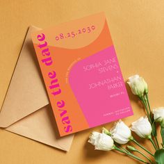 an orange and pink save the date card next to white flowers on a brown envelope