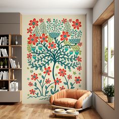 a living room with a tree painted on the wall next to a chair and bookshelf