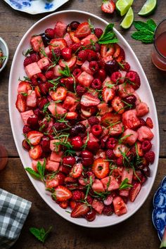 strawberries and cherries in a bowl with mint garnish on the side