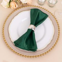 a place setting with green napkins and white plates