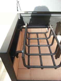 an open metal bed frame sitting on top of a tiled floor