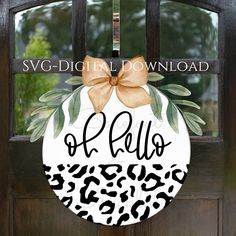 a door hanger with the word hello written in leopard print and a bow on it