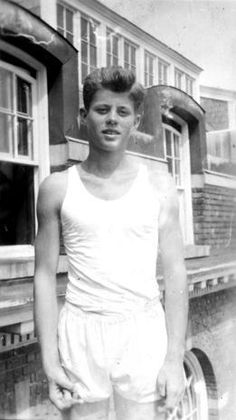 a man standing in front of a building holding a tennis racquet