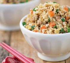 two bowls filled with rice and vegetables next to chopsticks