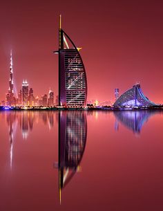 an image of a city at night with the bur in the foreground and its reflection in the water