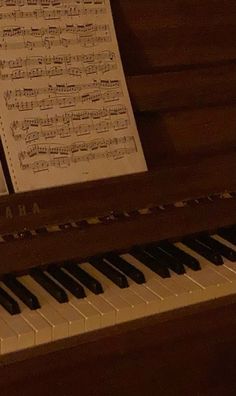 an old piano with sheet music on it's keys and some notes sitting next to it