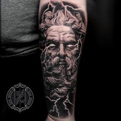 a man's arm with a black and grey tattoo on it, depicting the face of an old man