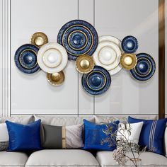 a living room filled with white couches and blue plates on the wall above them