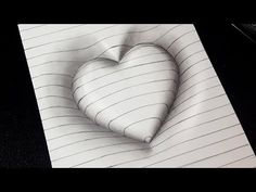 a drawing of a heart on top of lined paper next to a pen and pencil