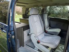 the interior of a blue van with grey seats