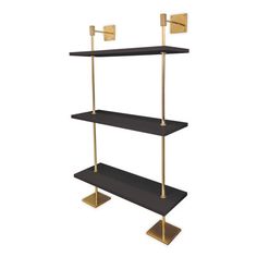 three tiered shelving unit with two brass - plated brackets and black shelves