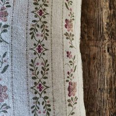 a close up of a pillow on a wooden surface