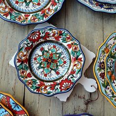 several colorful plates are arranged on a wooden table