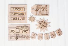 wooden cutouts with words and pictures on them, including sunflowers, flowers, and cars