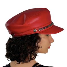 a woman wearing a red leather hat with chains on the brim and side view