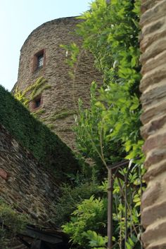 an old stone building with ivy growing on it's side and stairs leading up to the top