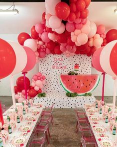 a watermelon themed birthday party with balloons and tableware set up on the tables