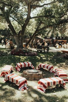 an outdoor fire pit surrounded by picnic tables