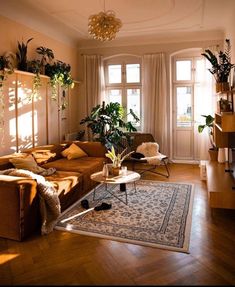 a living room filled with lots of furniture and plants on top of the windowsill