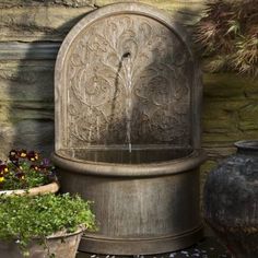 a water fountain surrounded by potted plants