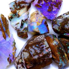 some very pretty purple and blue rocks on a white surface