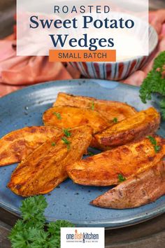 roasted sweet potato wedges on a blue plate with parsley garnishes