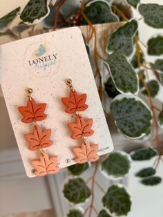 the earrings are orange and have leaves on them