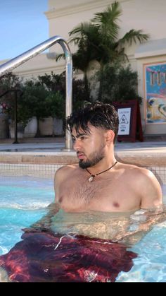 a man is in the pool with his shirt off and no shirt on, looking at something