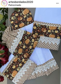 four pieces of cloth with pumpkins and lace on them sitting next to some flowers