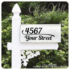 a white sign that says,'987 your street'in front of some bushes