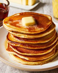 a stack of pancakes with butter on top and syrup in the middle, ready to be eaten