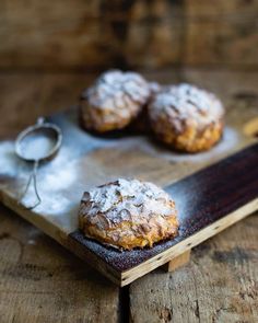 three pastries sitting on top of a wooden cutting board