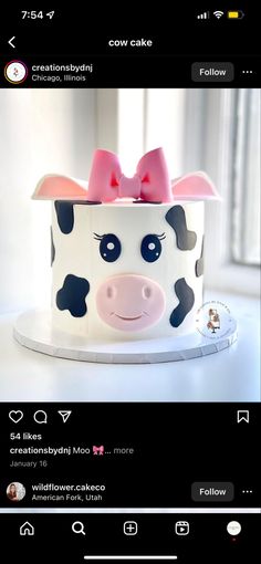 a cow cake with a pink bow on top