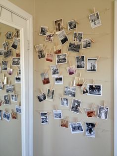 several pictures are hung on the wall and pinned to clothes pegs with clothes pins