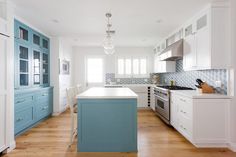 a kitchen with blue cabinets and white counter tops