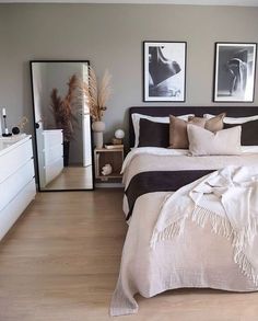 a large bed sitting in a bedroom next to two pictures on the wall above it