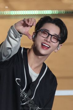 the young man is wearing glasses and smiling