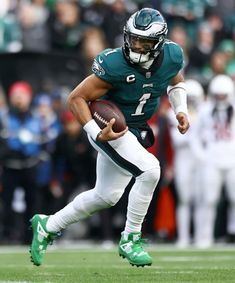 a football player running with the ball in his hand and people watching from the stands