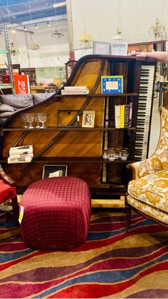 a living room filled with furniture and a grand piano in the corner next to a red ottoman