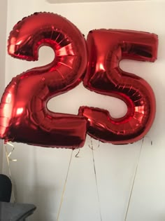 the number twenty five balloons are hanging on the wall