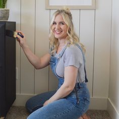 a woman is sitting on the floor with her legs crossed and holding something in one hand